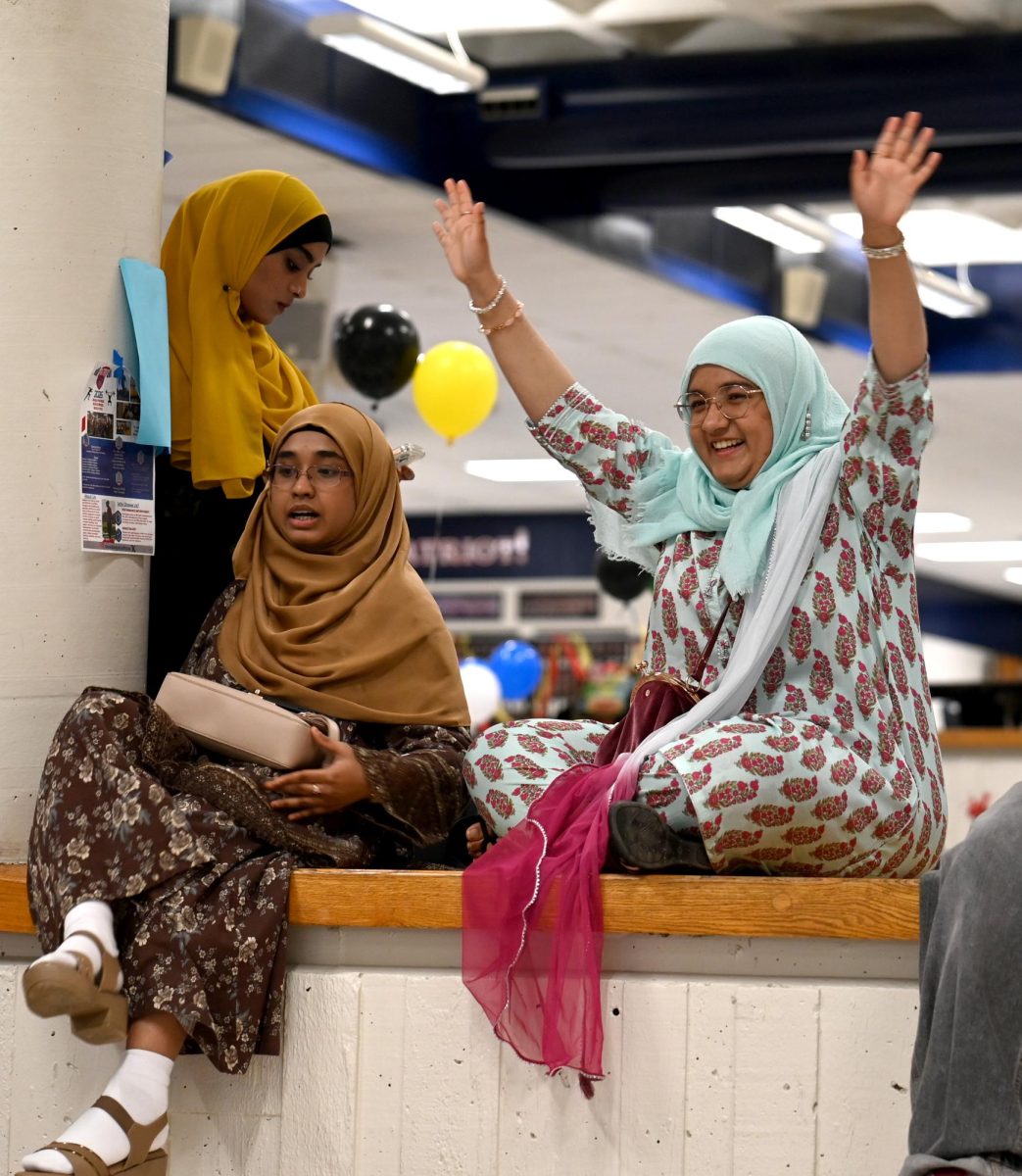 Wearing a traditional Pakistani salwar kameez, junior Adeena Ali greets her friends at Culture Night, April 8. With her are her friends, juniors Afifah Tasleem and Mahreen Fathima. "I think [Culture Night] was a really wonderful event that StuCo and the school put on. It was actually the one night that I was able to express my culture and my true self at school," Ali said. 