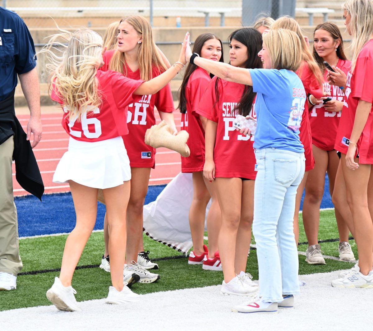 Attendance Secretary Carrie Bogad gives her daughter, senior Addie Bogad, a high five during the senior party, May 8.