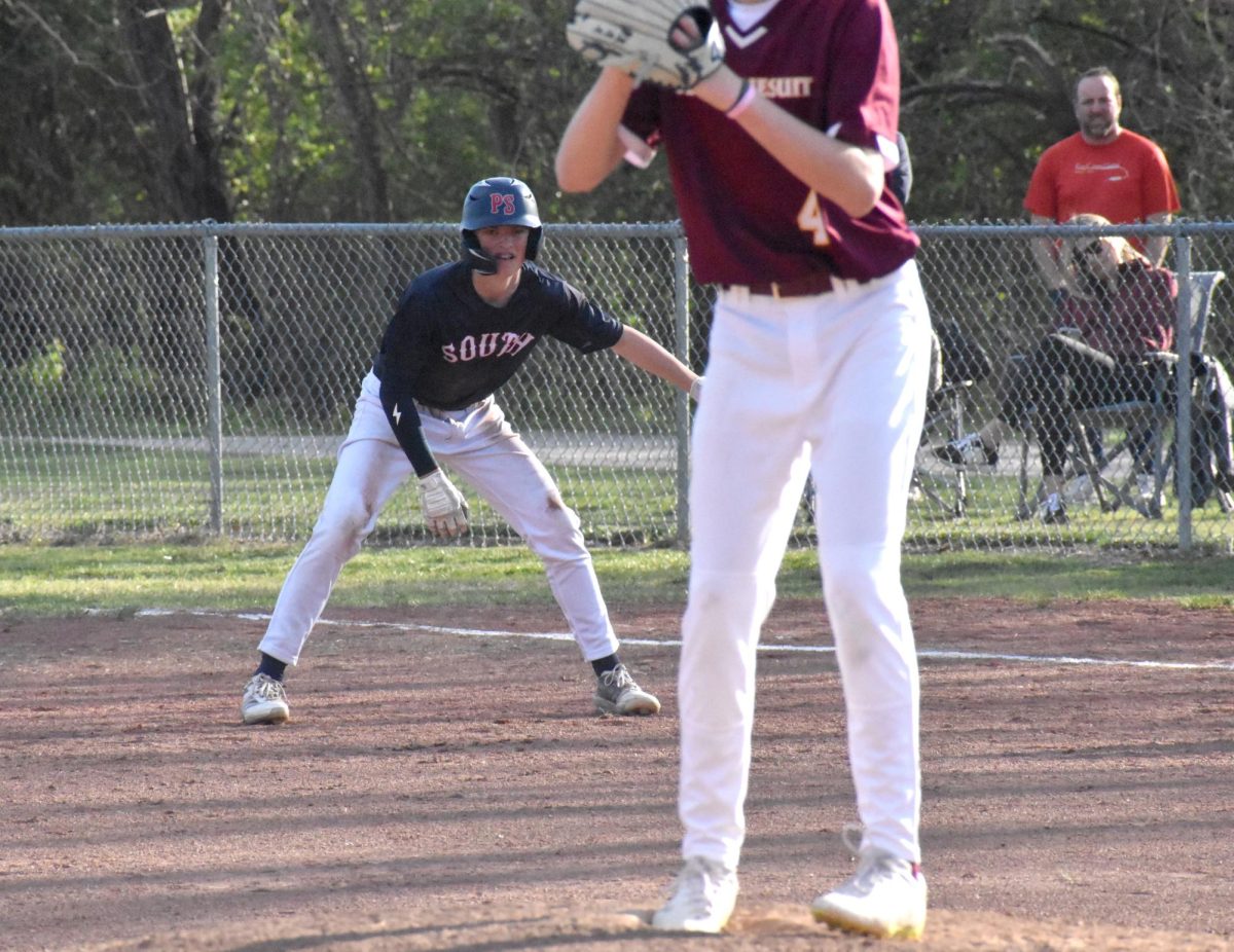 With his eyes locked on the pitcher, freshman Kalen Monzyk takes a lead, getting ready to steal second against the DeSmet Spartans, April 6. 