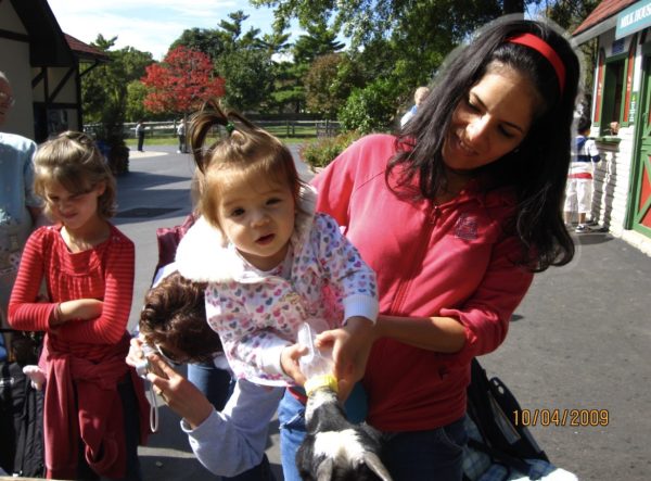 Junior Faith Mancuso as a 1 year old, held by her mom, Natalie, while she feeds the goats at Grant's Farm.