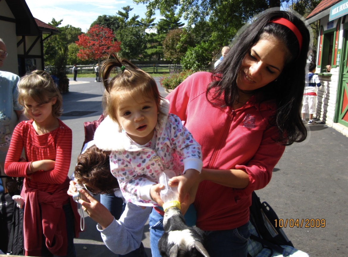 Junior Faith Mancuso as a 1 year old, held by her mom, Natalie, while she feeds the goats at Grant's Farm.