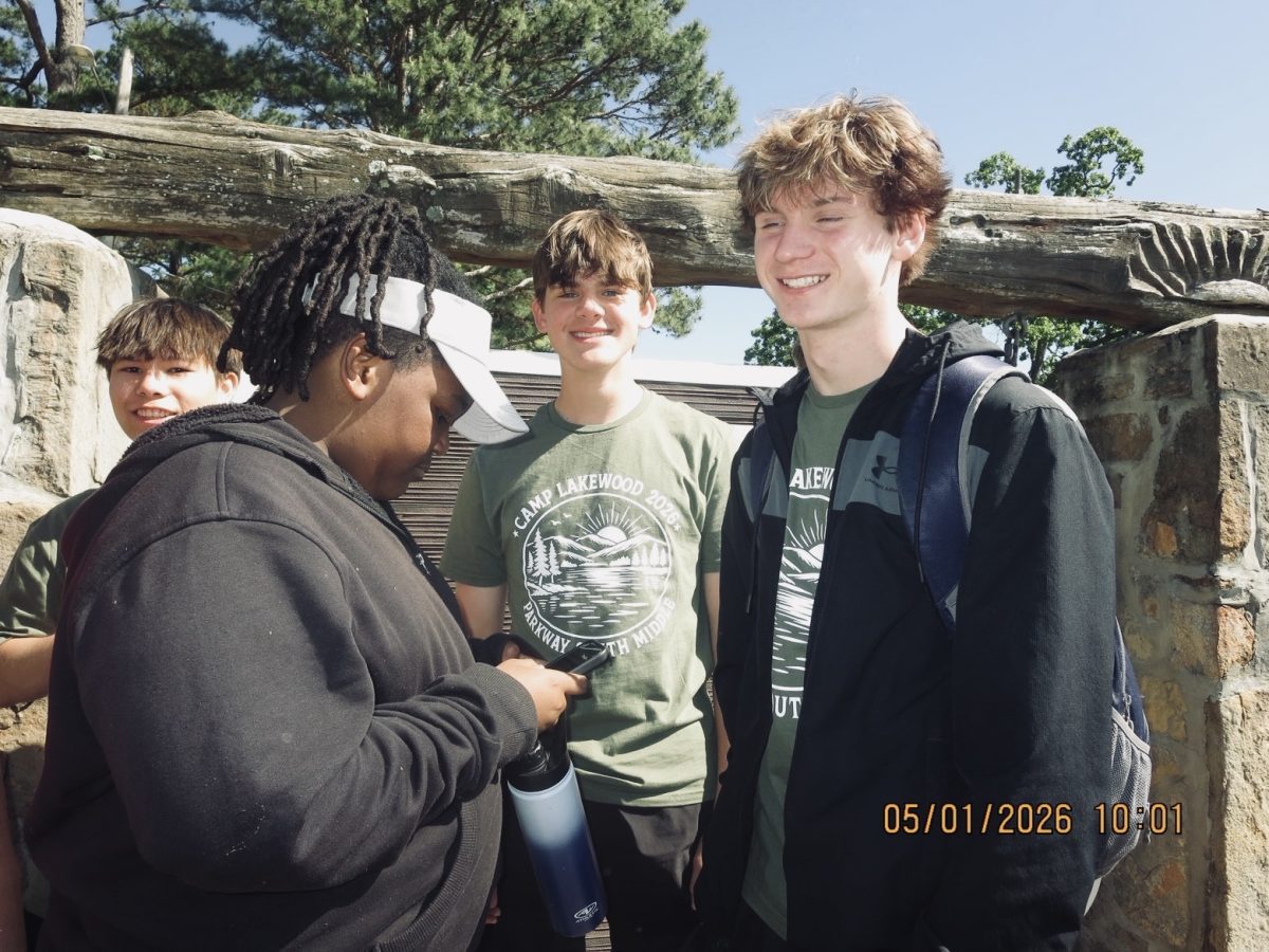A 6th grader shows counselors Quinton Wallace and Caden Jackson a funny video on the last day of 6th Grade Camp.