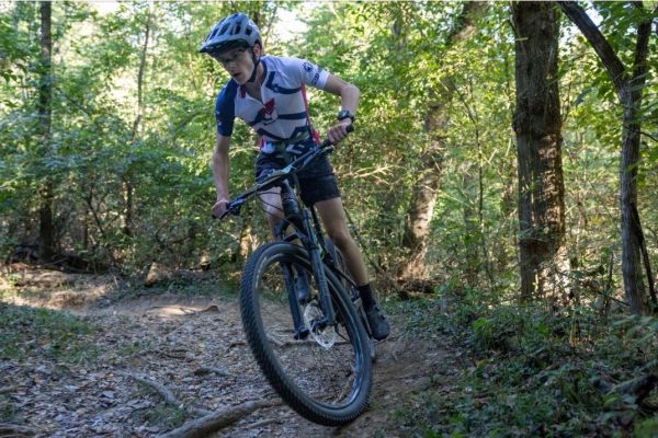 Racing for NICA (National Interscholastic Cycling Association), Noah McCallum makes a turn to stay on course, trying to finish in the valley park dirt crit race.